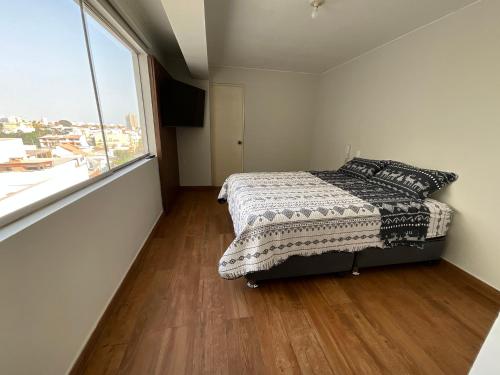 a bedroom with a bed and a large window at Apartment 4 Rent - Av San Borja Sur Cdra 4 in Lima