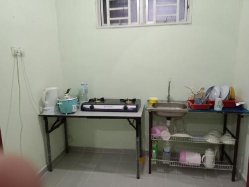 - une cuisine avec deux tables et un évier dans l'établissement Hana homestay D Yan Bedroom3, à Yan