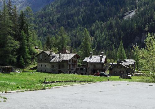 a group of houses in a field next to a mountain at Maison Chez Les Roset in Arvier