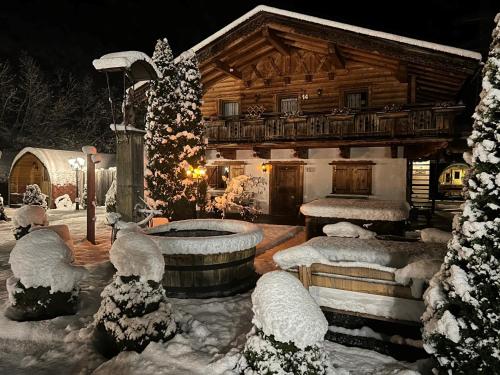 a log cabin with a tub in the snow at Gasthof Rafting Alm in Haiming