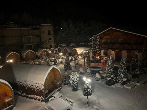 a courtyard covered in snow with christmas trees and lights at Gasthof Rafting Alm in Haiming