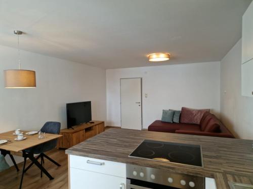 een keuken en een woonkamer met een tafel en een bank bij Apartment Pilz in Gosau