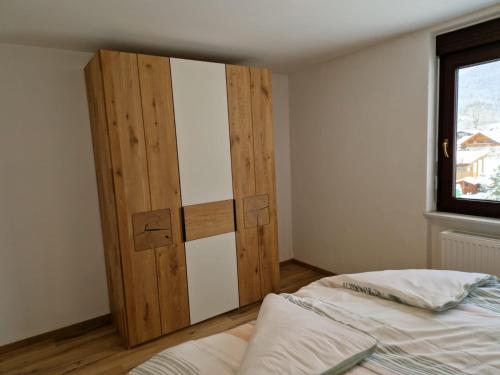 um quarto com uma cama e uma porta de madeira em Apartment Pilz em Gosau