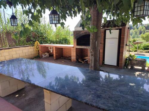 a large stone bench in a yard with a fireplace at Duplex con piscina en Rubí in Rubí