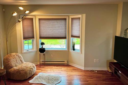 a living room with a chair and two windows at Entire house 3 min Drive to beach in Eastern Passage