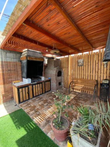 an outdoor patio with a grill and a bench at Casa descanso lluta in Arica