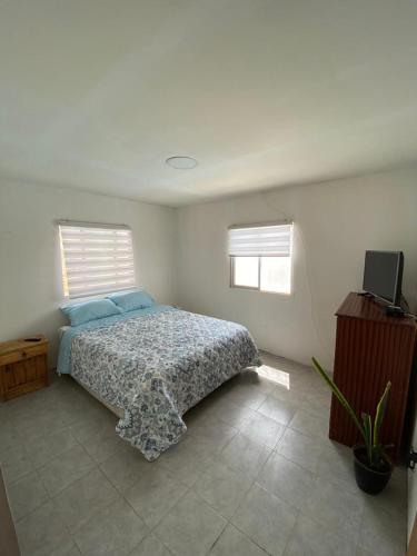 1 dormitorio con 1 cama y TV. en Casa descanso lluta, en Arica