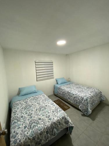 dos camas sentadas una al lado de la otra en una habitación en Casa descanso lluta, en Arica