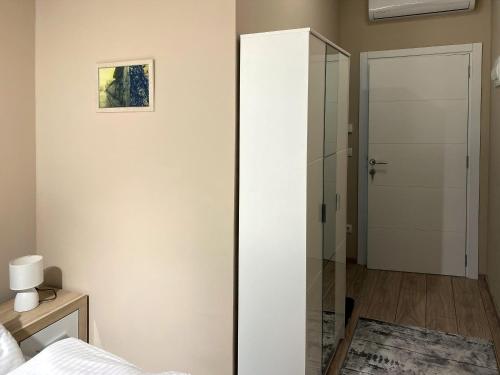 a glass partition in a bedroom with a bed at Brickrooms apartmani in Novi Pazar