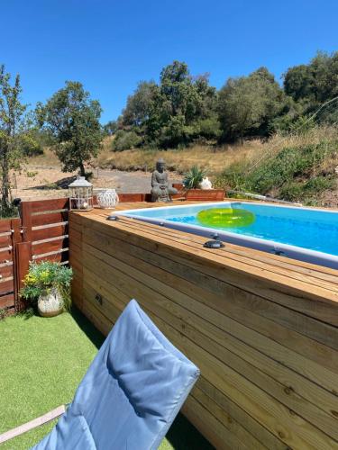 a swimming pool sitting on a deck next to a wooden fence at La Caseta de Raquel in Oristá