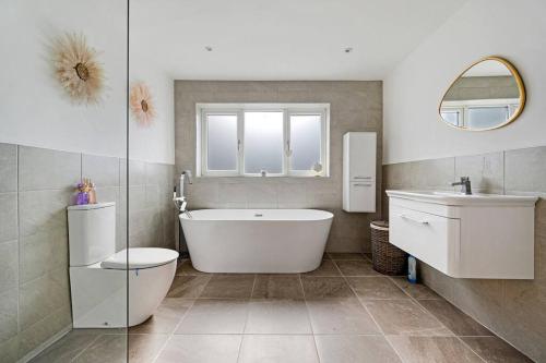 La salle de bains est pourvue d'une baignoire, de toilettes et d'un lavabo. dans l'établissement 3BD Retreat Boothstown Manchester, à Ellenbrook