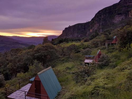 a group of tents on a hill at sunset at Mamaterra Glamping in Macanal