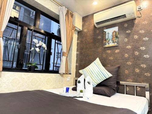 New International Guest House في هونغ كونغ: غرفة نوم بسرير ونافذة بها مكيف