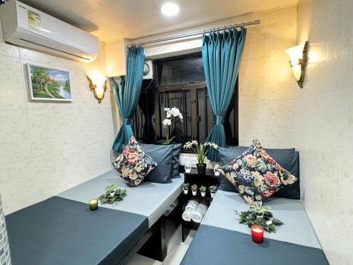 una habitación con 2 sofás azules y una ventana en New International Guest House, en Hong Kong