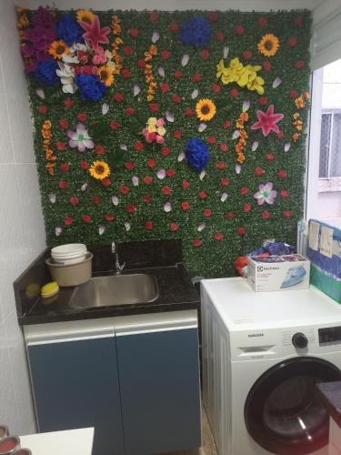 a kitchen with a flower wall behind a sink at Paraíso dos Viajantes - O PREFERIDO in Salvador