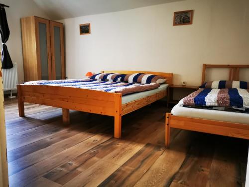 two beds in a room with wooden floors at Drevenica Spanka in Špania Dolina