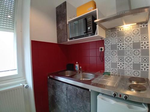 a small kitchen with a sink and a microwave at Guest Home location in Néris-les-Bains