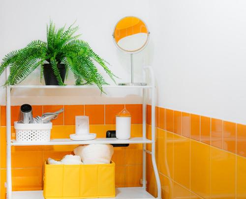 ein Badezimmer mit orangefarbenen Fliesen und ein Regal mit einem Spiegel in der Unterkunft ZenHouse - Nel cuore del centro storico di Torino in Turin