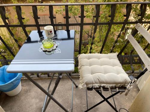 a table and chair on a balcony with a drink at Diko in Barcelona