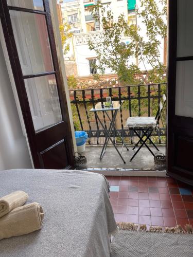 eine Tür zu einem Balkon mit einem Tisch und einem Stuhl in der Unterkunft Diko in Barcelona