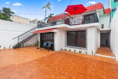 a house with a balcony with a red umbrella at Casa Nance Alojamientos COBA Mercado 28 Smart TV y ADO Centro in Cancún