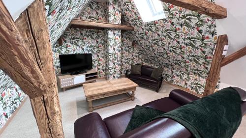 uma sala de estar com um sofá e uma televisão em Joseph, Adeline & Nous (Gîte au coeur du vignoble) em Rorschwihr