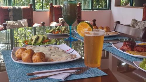 a table with plates of food and a glass of beer at New Paradise Casa Campestre in Villeta