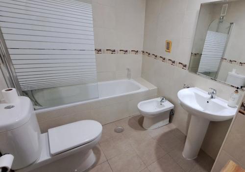 a bathroom with a toilet and a sink and a bath tub at El Rincón del Pisuerga con Terraza in Cabezón de Pisuerga