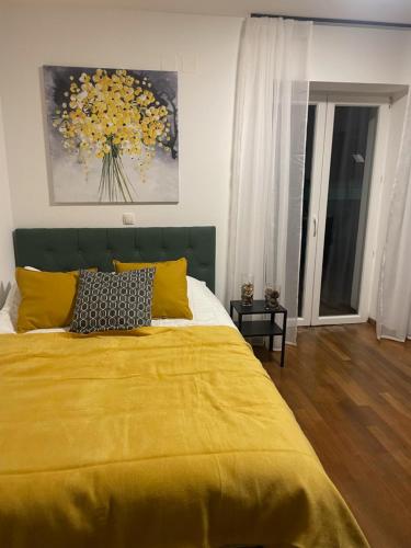 1 dormitorio con 1 cama amarilla con manta amarilla en Sunny studio with nice mountain view from terrace, en Jesenice