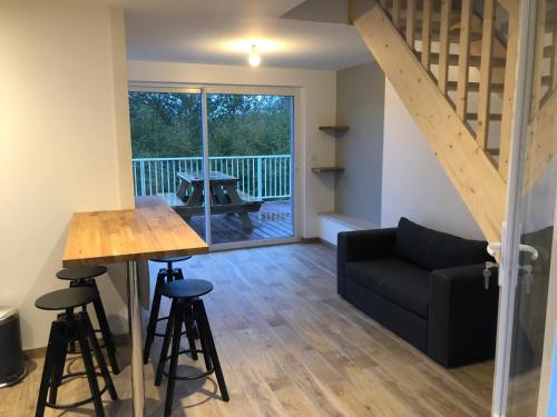ein Wohnzimmer mit einem Tisch und einem Sofa in der Unterkunft La petite maison in Putanges