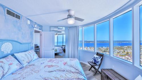 1 dormitorio con 1 cama con paredes y ventanas azules en On the Beach-2/Br 2/Bath, 26th floor! Spectacular views of Ocean & River en Daytona Beach Shores