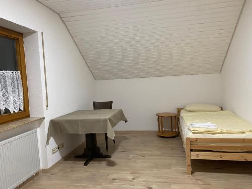 KönigsbronnにあるRuhige 4 Zimmer OG-Wohnung Z2のテーブルとベッドが備わる部屋