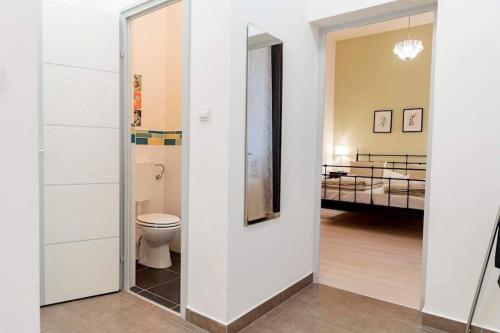 a bathroom with a toilet and a bedroom at Sweet Relax House in Budapest