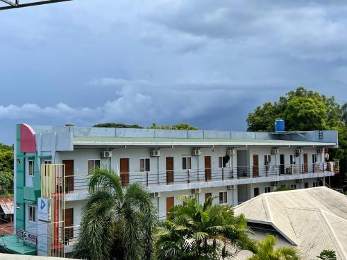 un edificio blanco con techo azul y palmeras en Japandi-inspired Hideaway, en Dumaguete