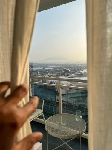 a person looking out of a window at a table at The Patio at Monaco Tower in Lagundi
