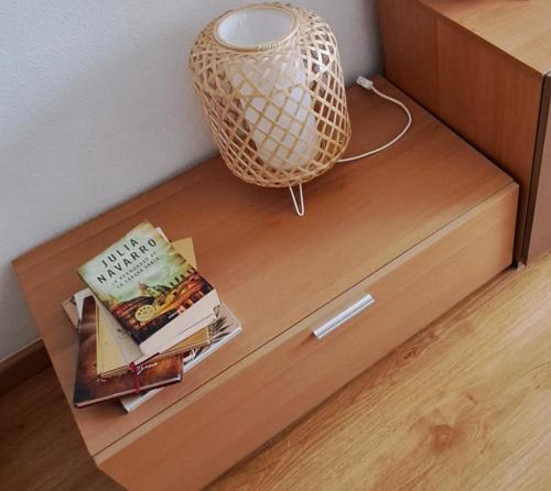 a book sitting on top of a wooden drawer at El Rincón del Pisuerga con Terraza in Cabezón de Pisuerga