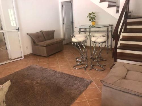 a living room with a table and chairs and a staircase at Casa em Teresopolis in Teresópolis