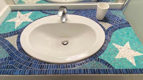 a sink in a bathroom with blue and white tiles at Appart à St Martin de Ré in Saint-Martin-de-Ré