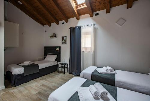 レッコにあるLa Casa del Sarto - Rooms and Apartmentsのベッド3台と窓が備わる客室です。