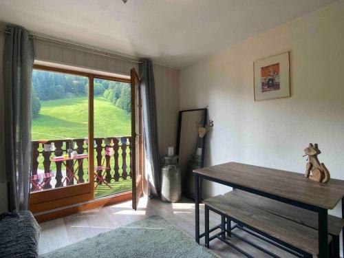 Zimmer mit einem Tisch und Blick auf einen Balkon in der Unterkunft Cozy studio between the lake and the mountain in Le Biot