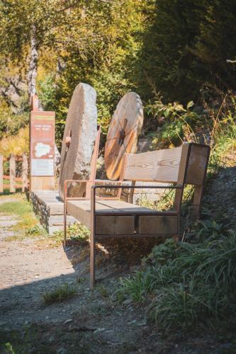 a bench in a park with two large rocks at Casa amb molt encant i tranquilitat. in Ansalonga