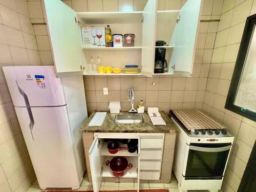een kleine keuken met een koelkast en een wastafel bij Apto Centro Moderno e Completo in Ribeirão Preto