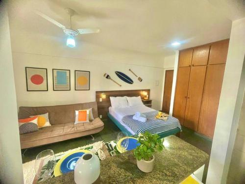 een woonkamer met een bed en een bank bij Apto Centro Moderno e Completo in Ribeirão Preto