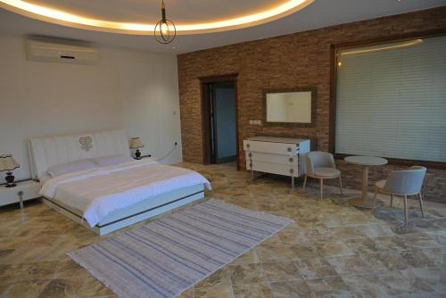 a bedroom with a bed and a table and chairs at منتجع بيت الريف in Al Hofuf