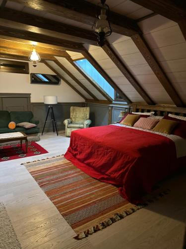 Un dormitorio con una cama con un edredón rojo. en San, en Bijeljina