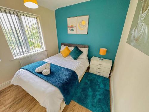 een slaapkamer met een bed met een blauwe muur bij HILLTOP PLACE SUITES , Parkway M1 J33 in High Hazels