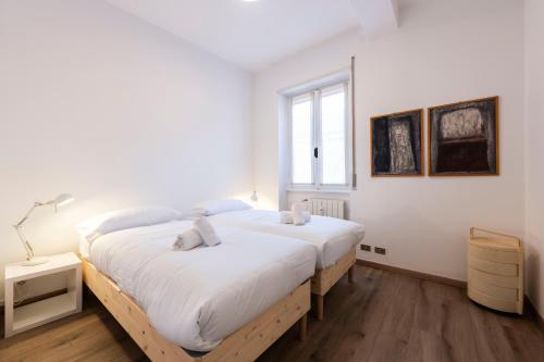 biała sypialnia z 2 łóżkami i oknem w obiekcie Residenza Astra w Weronie