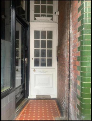 une porte blanche sur le côté d'un bâtiment en briques dans l'établissement Studio Apartment Eastbourne Town Centre South Street, à Eastbourne