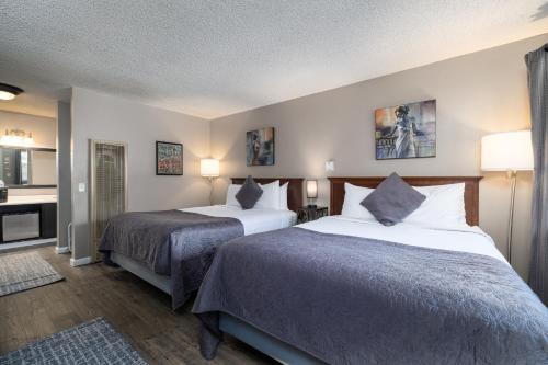 a hotel room with two beds and a bathroom at The Alder Inn in South Lake Tahoe