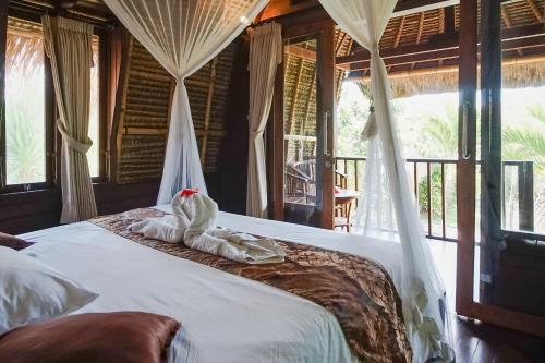 a bedroom with a bed with an elephant on it at Abian Cottage Lembongan in Nusa Lembongan
